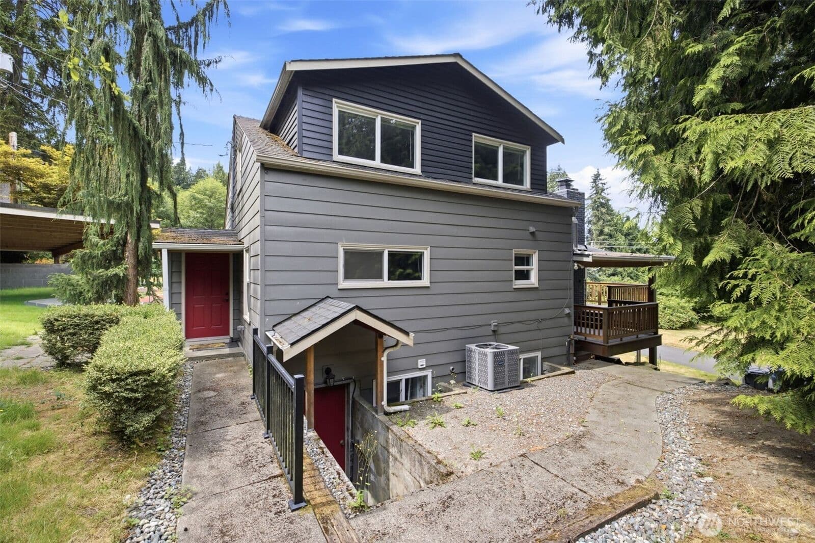 Side elevation showing two separate red entry doors — one reached by a walkway to the main level, the other down its own railed stairwell to the lower level.